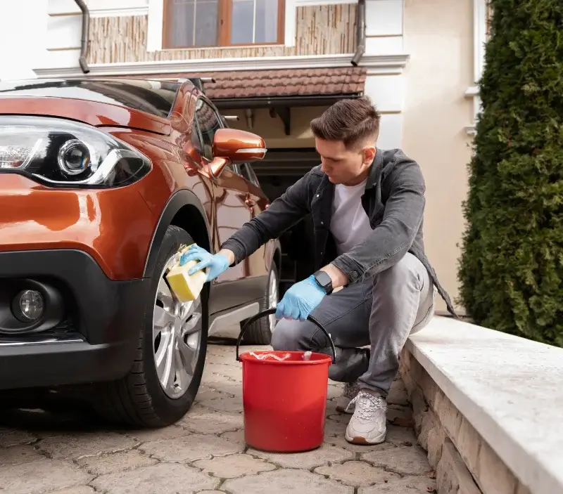 Lavage auto à domicile Saint-Georges-sur-Erve : professionnel intervenant sur un véhicule